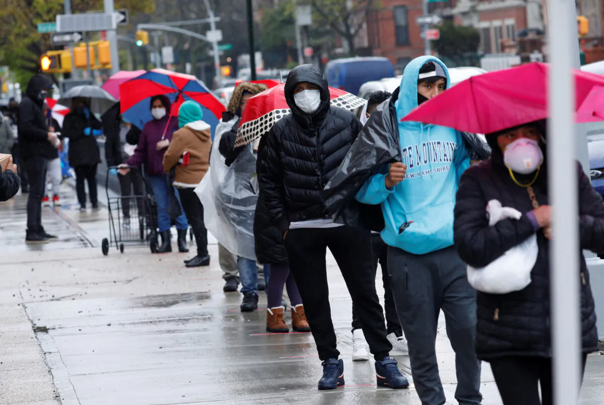 People wait in line to receive free food at a curbside pantry in New York City on April 24, 2020. (Mike Segar/Reuters)