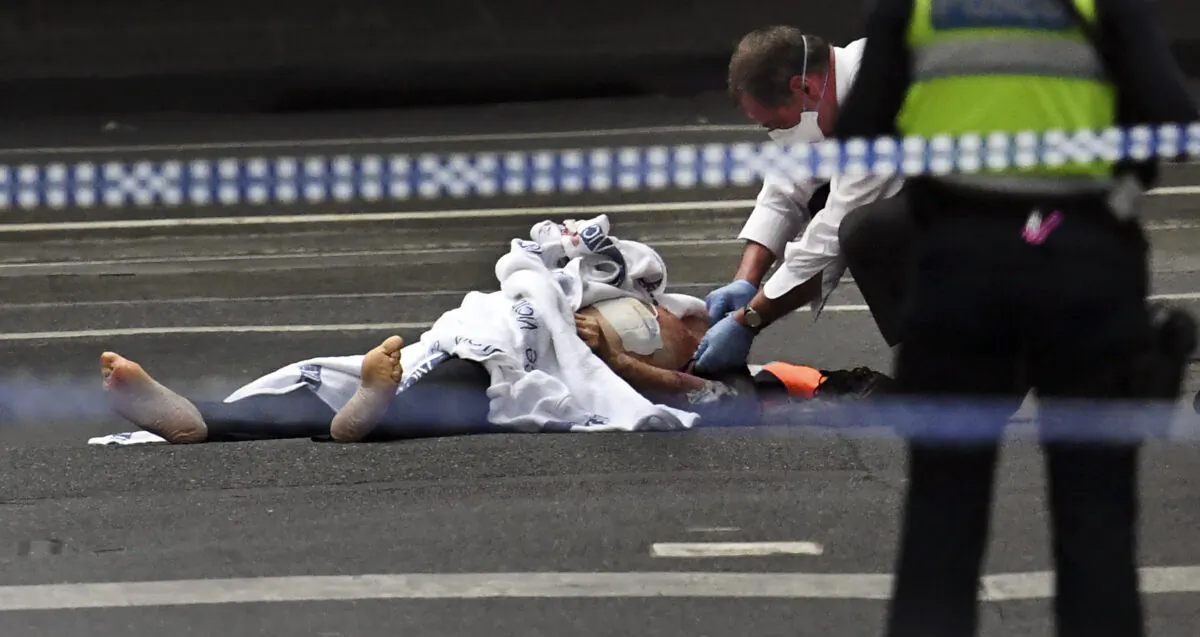 A police officer inspects a body at the crime scene following a stabbing incident in Melbourne on November 9, 2018. (William WEST / AFP)        