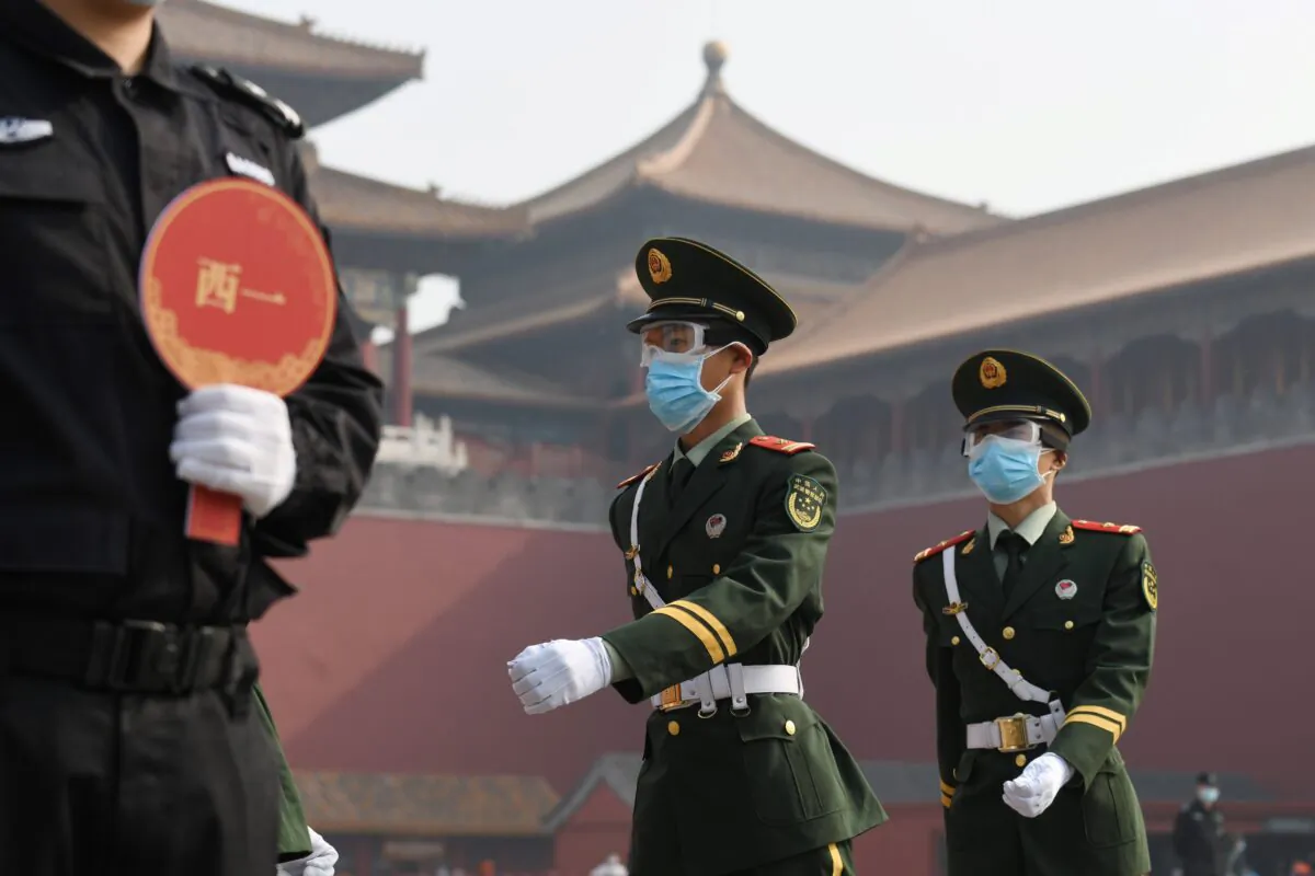 Paramilitary police officers wear face masks and goggles amid concerns of the COVID-19 CCP virus as they march outside the Forbidden City, the former palace of China's emperors, in Beijing, China, on May 1, 2020. (Greg Baker/AFP/Getty Images)