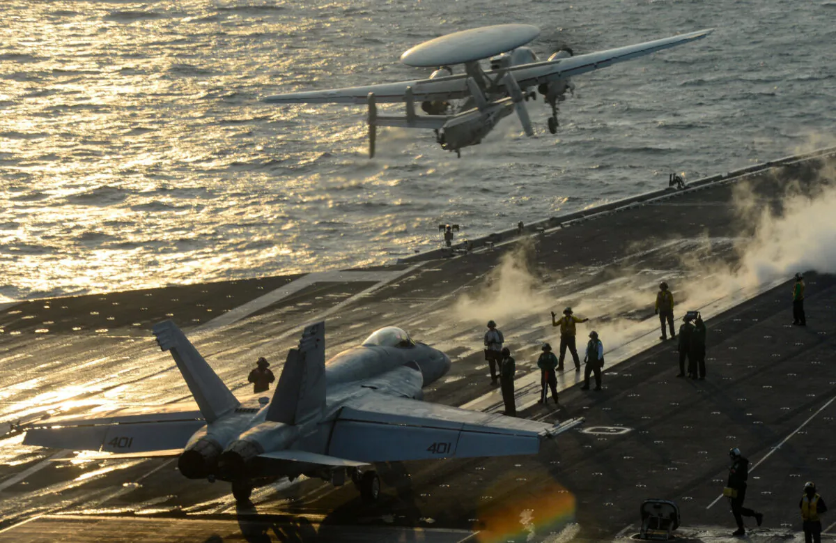 An F/A-18E Super Hornet lines up on a catapult on the flight deck while an E-2D Hawkeye takes off from the U.S. Navy aircraft carrier USS Harry S. Truman in the Arabian Sea, on Jan.11, 2020. (U.S. Navy/Mass Communication Specialist Seaman Apprentice Isaac Esposito/File Photo/Handout/Reuters)