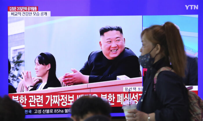A woman passes by a TV screen showing an image of North Korean leader Kim Jong Un and his sister Kim Yo Jong during a news program at the Seoul Railway Station in Seoul on May 2, 2020. (Ahn Young-joon/AP Photo)
