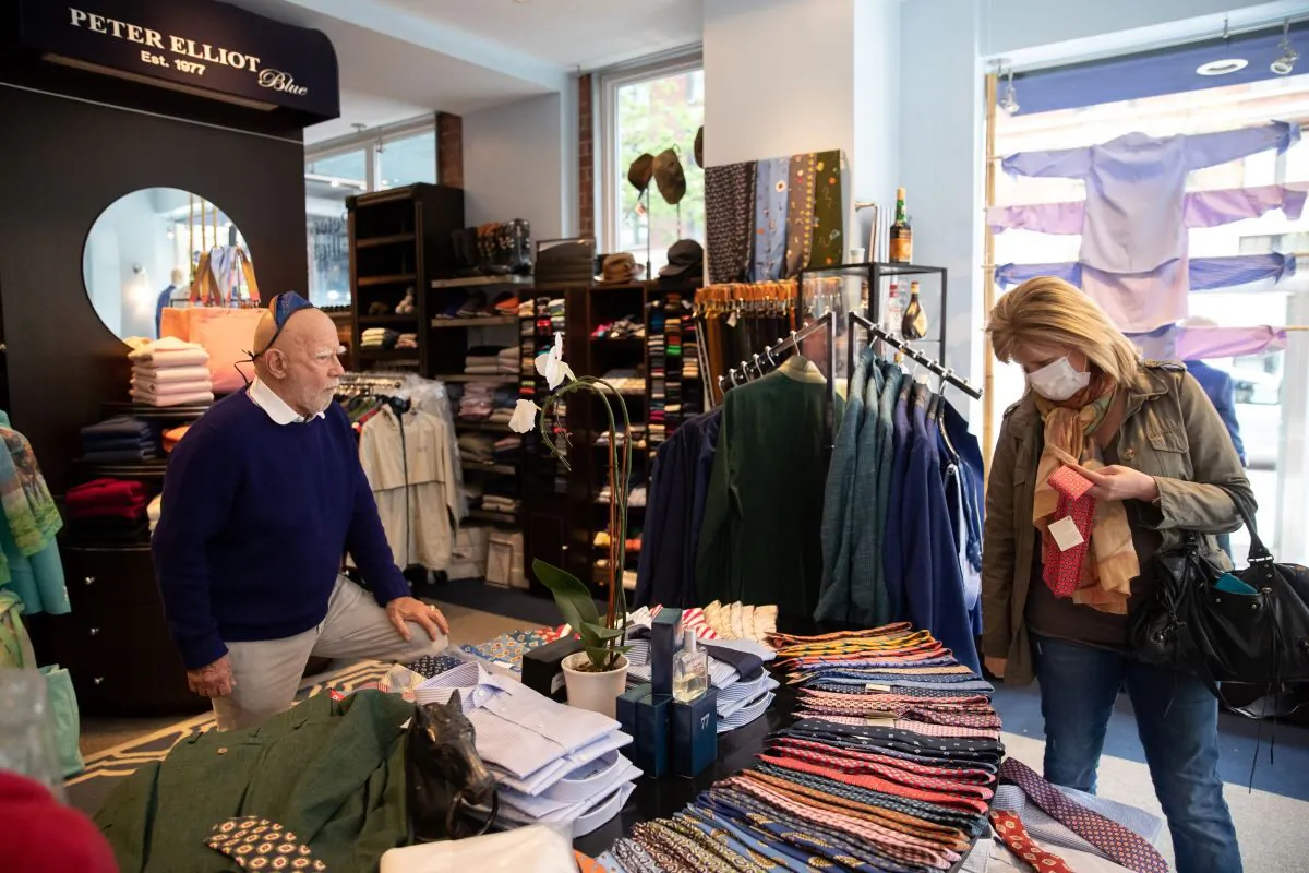 A customer shops at Peter Elliot boutique in New York City on April 29, 2020. Eliot Rabin, the owner of the boutique (L) is keeping his store open because he objects to the state order deeming his business non-essential, and says he has received widespread support for his stance. (Jeenah Moon/Getty Images)