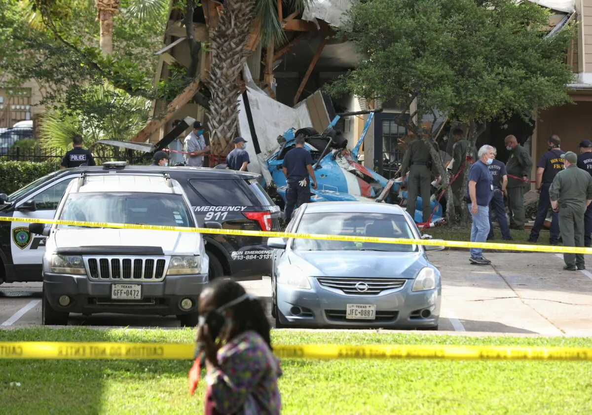Authorities investigate the scene of a helicopter crash at an apartment complex in Houston on May 2, 2020. (Jon Shapley/Houston Chronicle via AP)