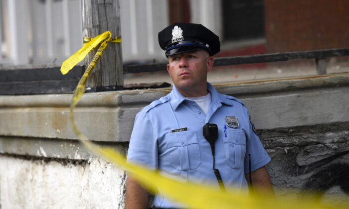 A police officer monitors activity near a residence while responding to a shooting in Philadelphia, Penn., in a file photo. (Mark Makela/Getty Images)