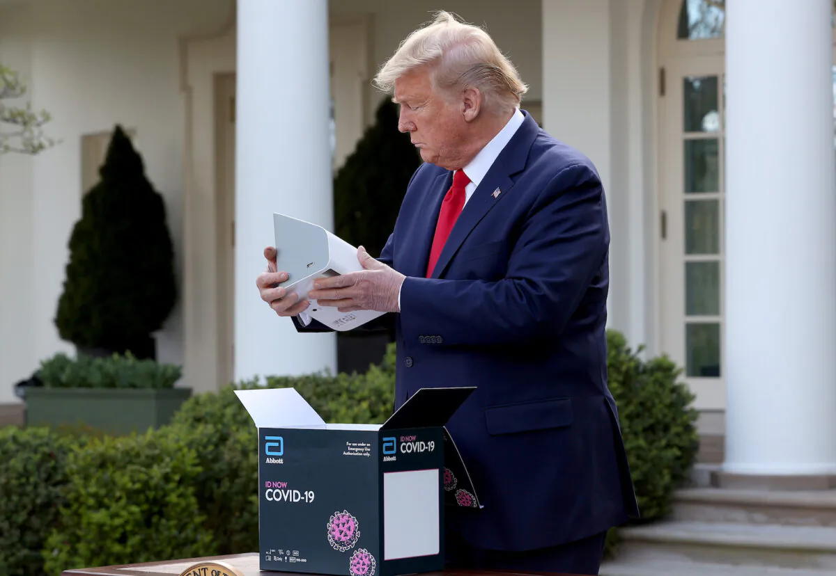 President Donald Trump holds a rapid COVID-19 test kit developed by Abbott Labs at the Rose Garden of the White House in Washington on March 30, 2020. (Win McNamee/Getty Images)