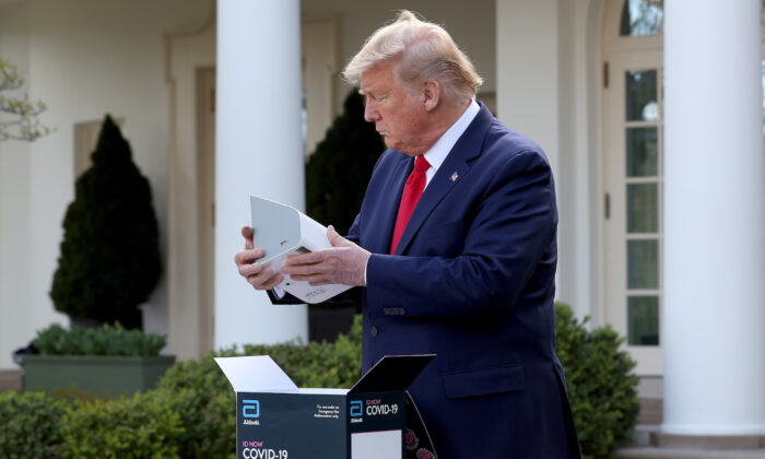 President Donald Trump holds a rapid COVID-19 test kit developed by Abbott Labs at the Rose Garden of the White House in Washington on March 30, 2020. (Win McNamee/Getty Images)