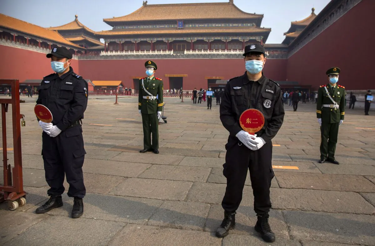 Chinese paramilitary police and security officers stand guard outside an entrance to the Forbidden City in Beijing on May 1, 2020. (Mark Schiefelbein/AP Photo)