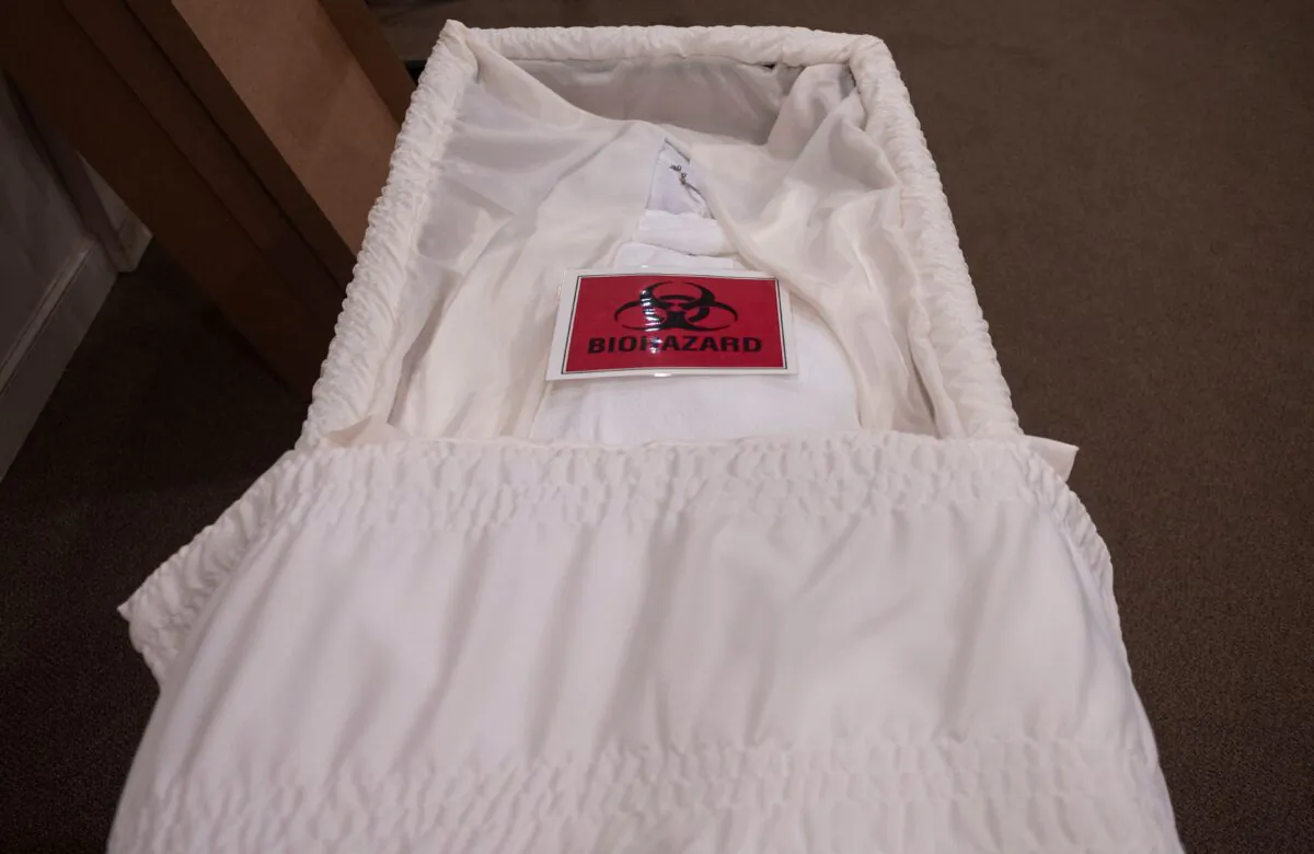 A biohazard sign is seen on the body of a COVID-19 victim in a casket at the Stauffer Funeral Homes in Frederick, Maryland, on May 1, 2020. (Andrew Caballero-Reynolds/AFP via Getty Images)