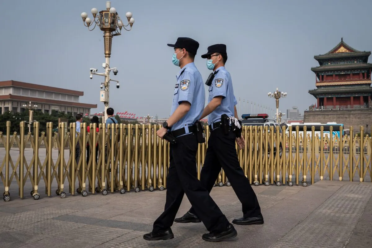 Police officers patrol an area outside Beijing's Tiananmen Square (back) on World Press Freedom Day on May 3, 2020. (Nicolas Asfouri/AFP via Getty Images)