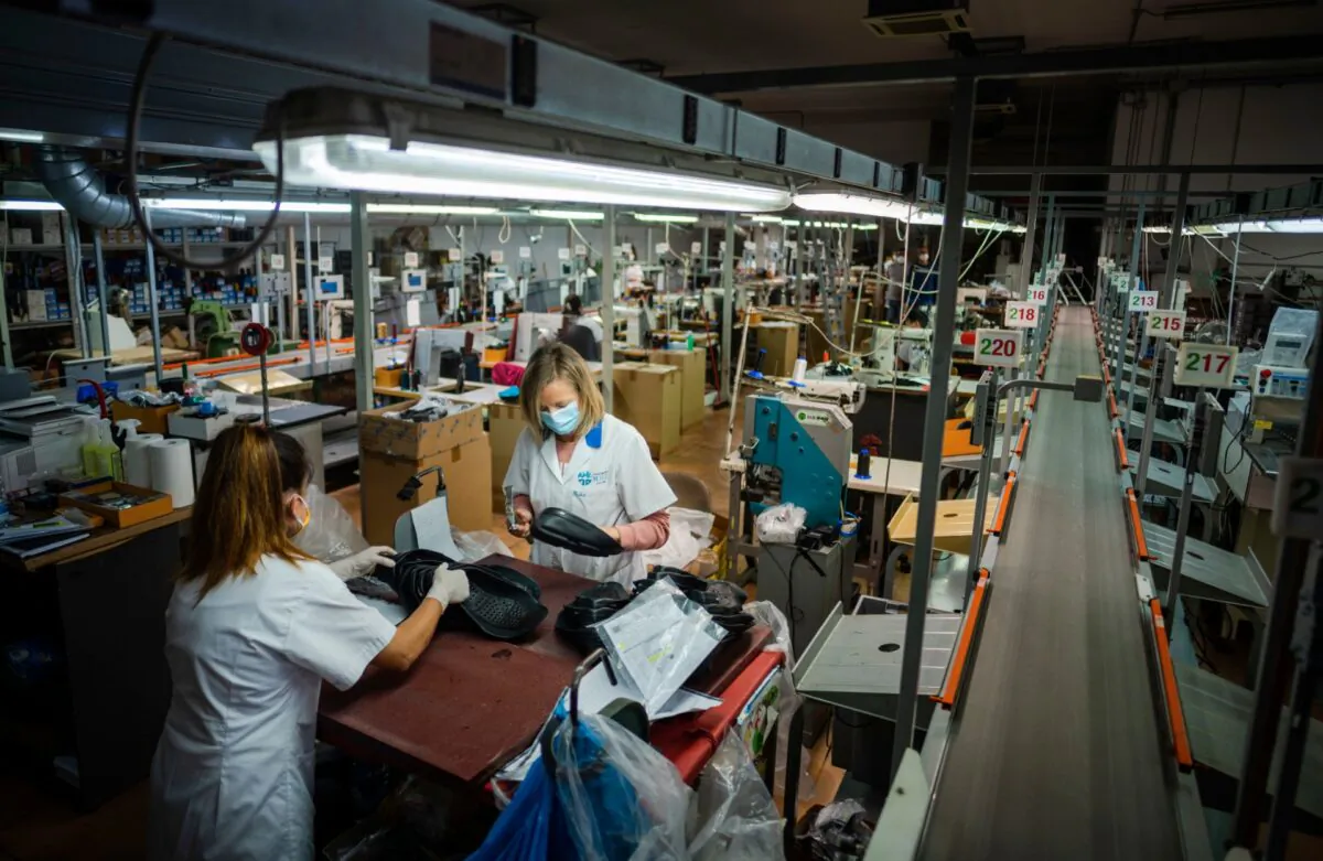Workers of the Calzaturificio M.G.T shoe factory in Castelnuovo Vomano, central Italy, return to work, on May 4, 2020. (Domenico Stinellis/AP Photo)