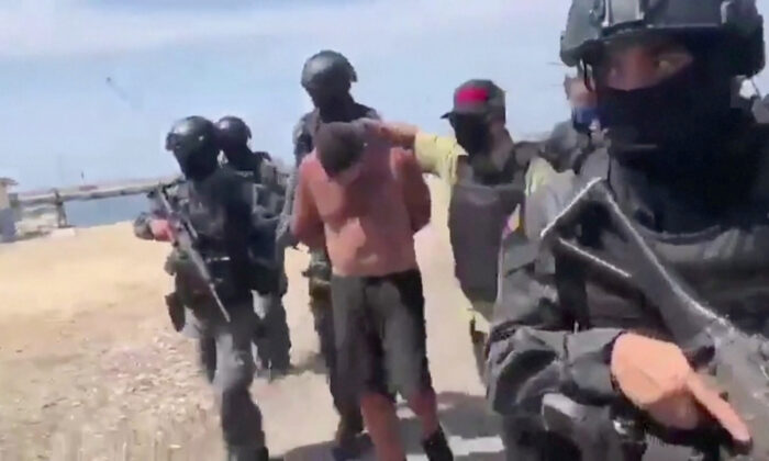 Venezuelan soldiers in balaclavas move a suspect from a helicopter after what Venezuelan authorities described was a 