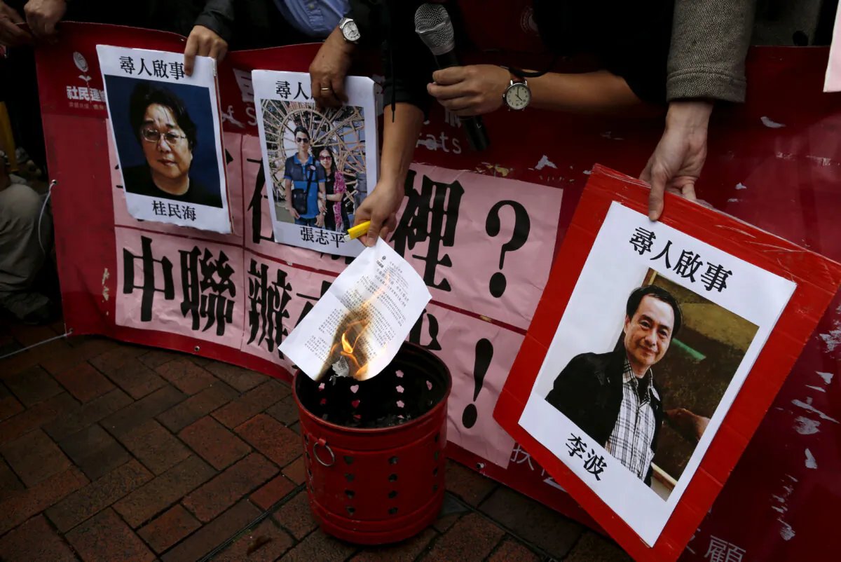 A pro-democracy demonstrator burns a letter next to pictures of missing staff members of a publishing house and a bookstore, including Gui Minhai, a China-born Swedish national who is the owner of Mighty Current, Cheung Jiping, the business manager of the publishing house and Causeway Bay Books shareholder Lee Bo (L-R), during a protest to call for an investigation behind their disappearance, outside the Chinese liaison office in Hong Kong, China, on Jan. 3, 2016. (Tyrone Siu/Reuters)
