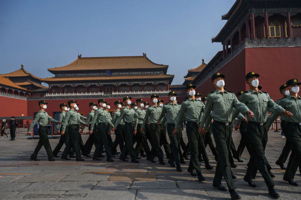 Chinese paramilitary police wearing protective masks march by the entrance to the Forbidden City in Beijing on May 2, 2020. (Kevin Frayer/Getty Images)