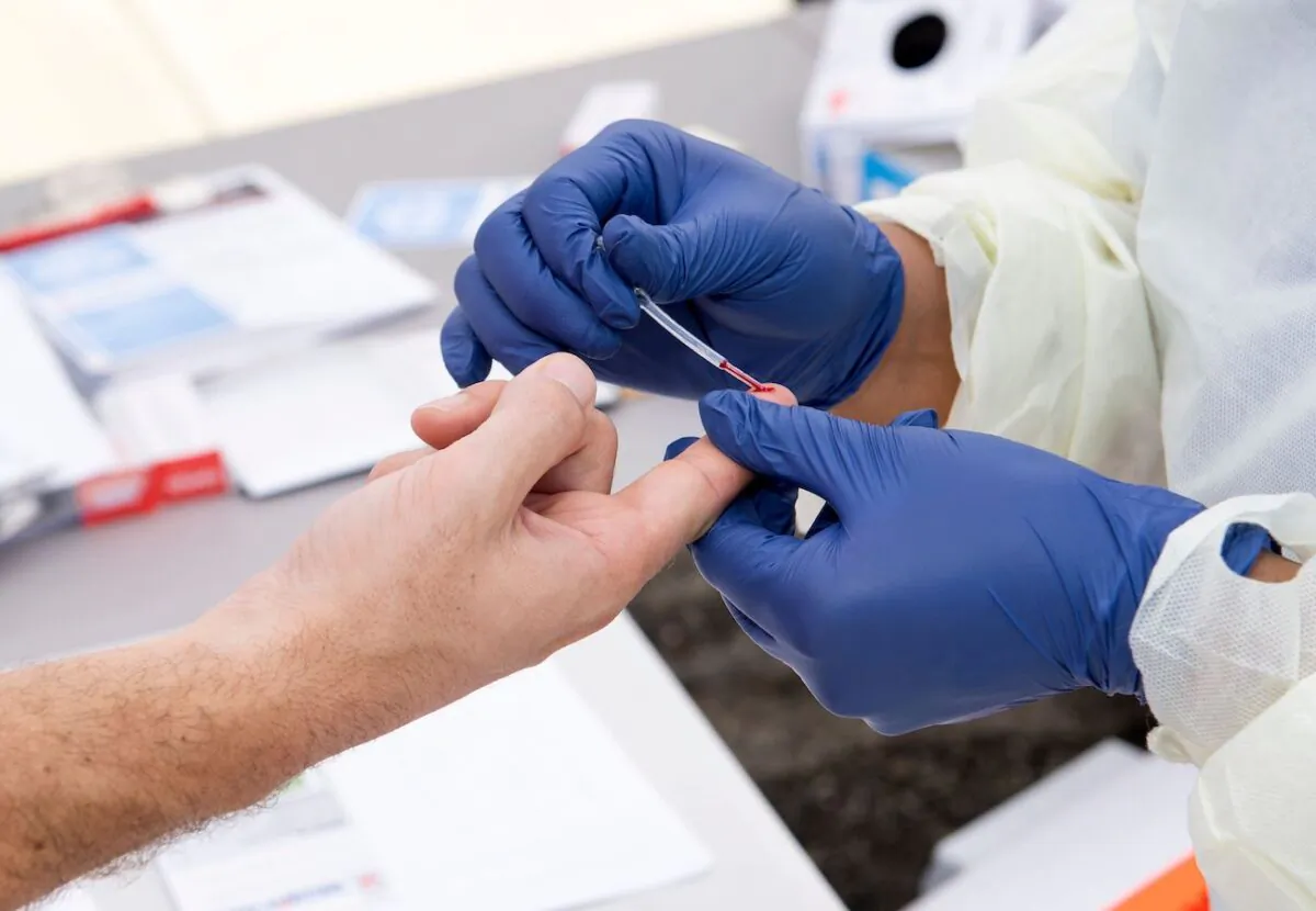 A health worker takes a drop of blood for a COVID-19 antibody test in Torrance, Calif., on May 5, 2020. (Valerie Macon/AFP/Getty Images)