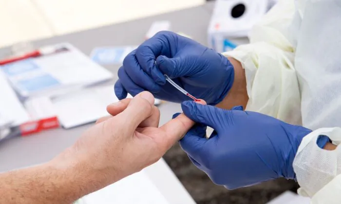 A health worker takes a drop of blood for a COVID-19 antibody test in Torrance, Calif., on May 5, 2020. (Valerie Macon/AFP/Getty Images)