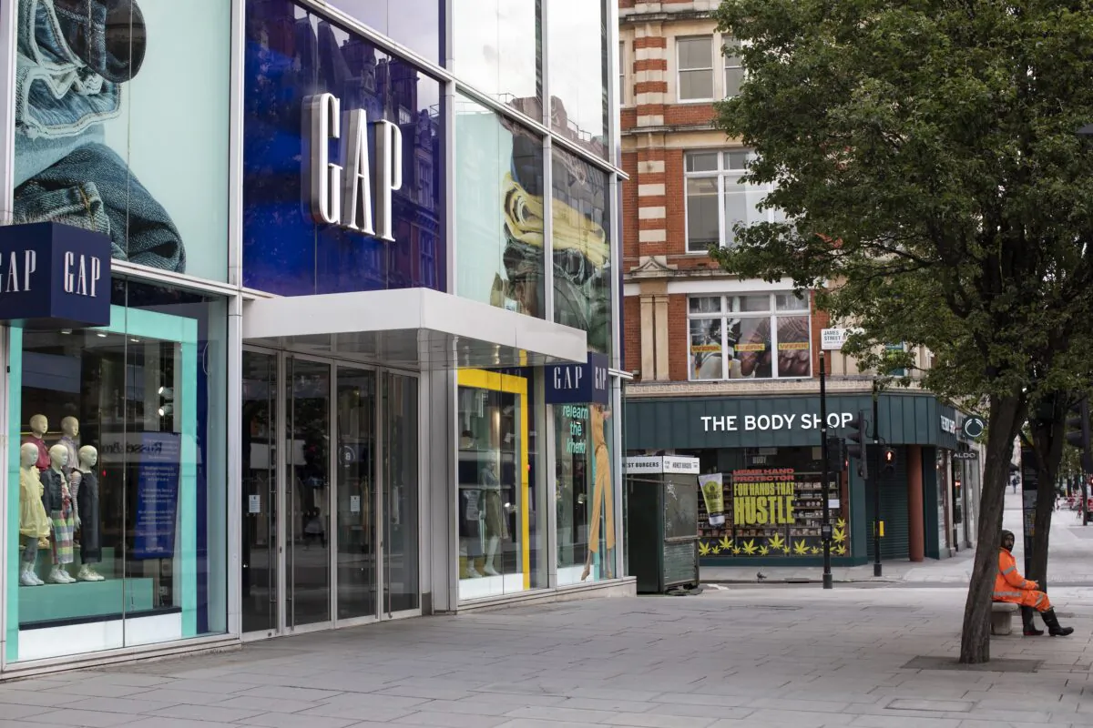 A man sits outside a closed Gap store in London, UK, on May 1, 2020. (Dan Kitwood/Getty Images)