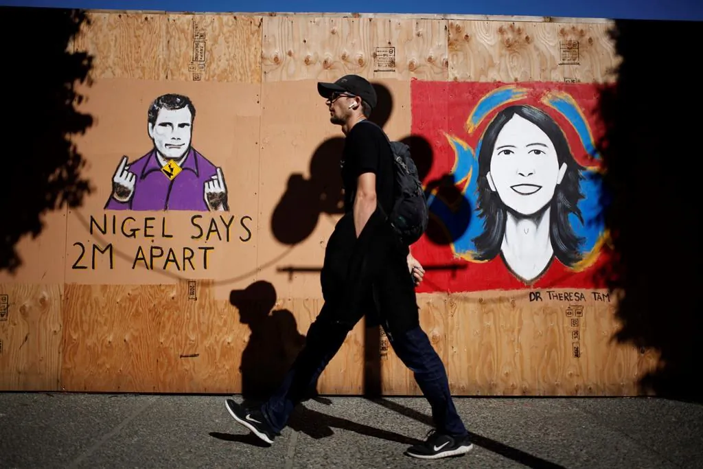 People walk by a mural of sign-language interpreter Nigel Howard and Chief Public Health Officer Dr. Theresa Tam created by artist Ian Morris seen along Government St. in Victoria, B.C., on May 6, 2020. (The Canadian Press/Chad Hipolito)