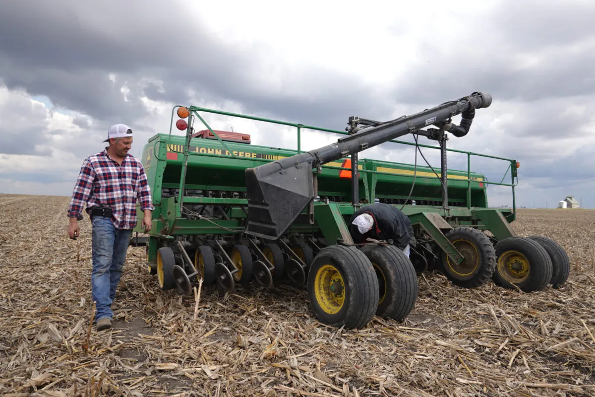 John Duffy (R) and his son Dan make a repair to a grain drill while planting soybeans near Dwight, Ill., on April 23, 2020. (Scott Olson/Getty Images)