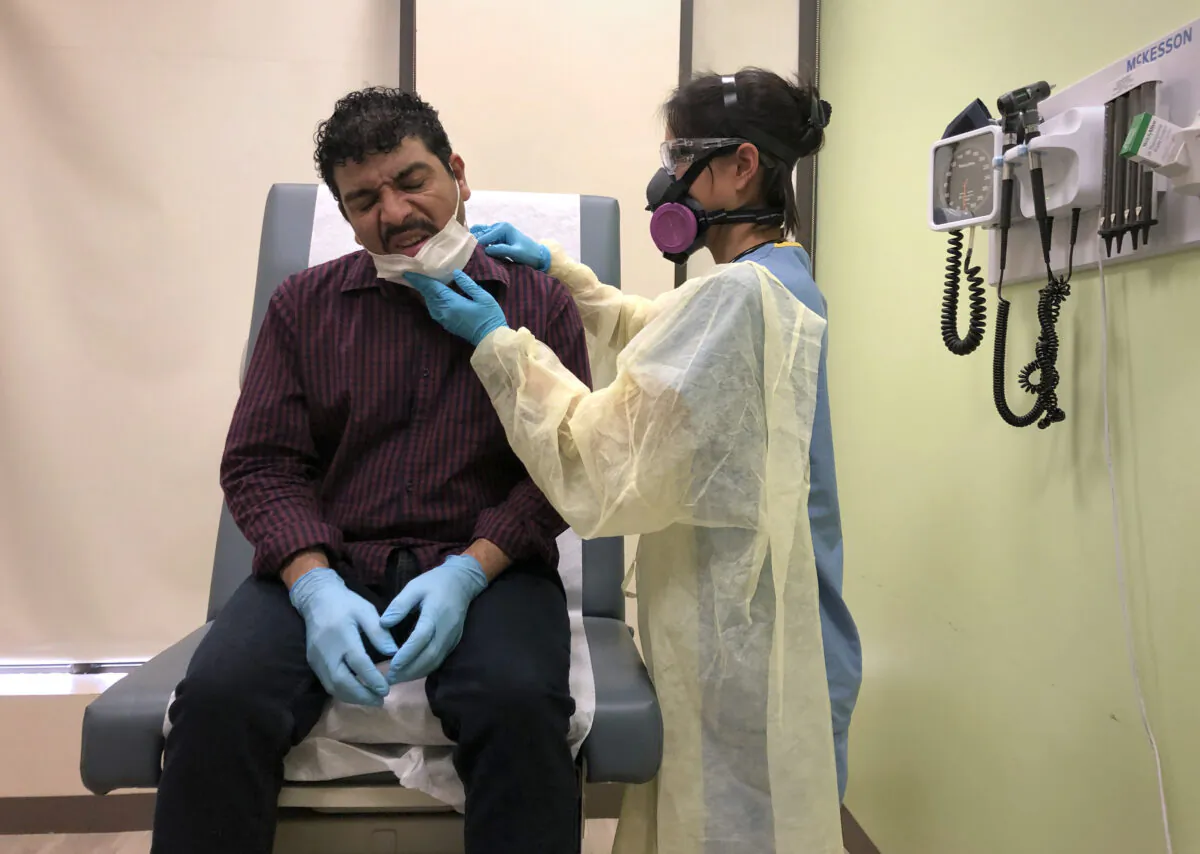 A patient is checked by a physician's assistant before receiving a COVID-19 swab test at a clinic in Stamford, Conn. on May 5, 2020. (John Moore/Getty Images)