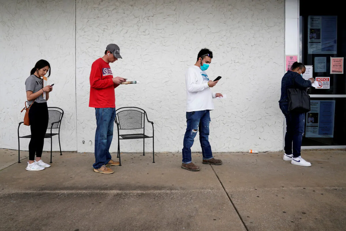 People who lost their jobs wait in line to file for unemployment at an Arkansas Workforce Center in Fayetteville, Ark., on April 6, 2020. (Nick Oxford/Reuters)