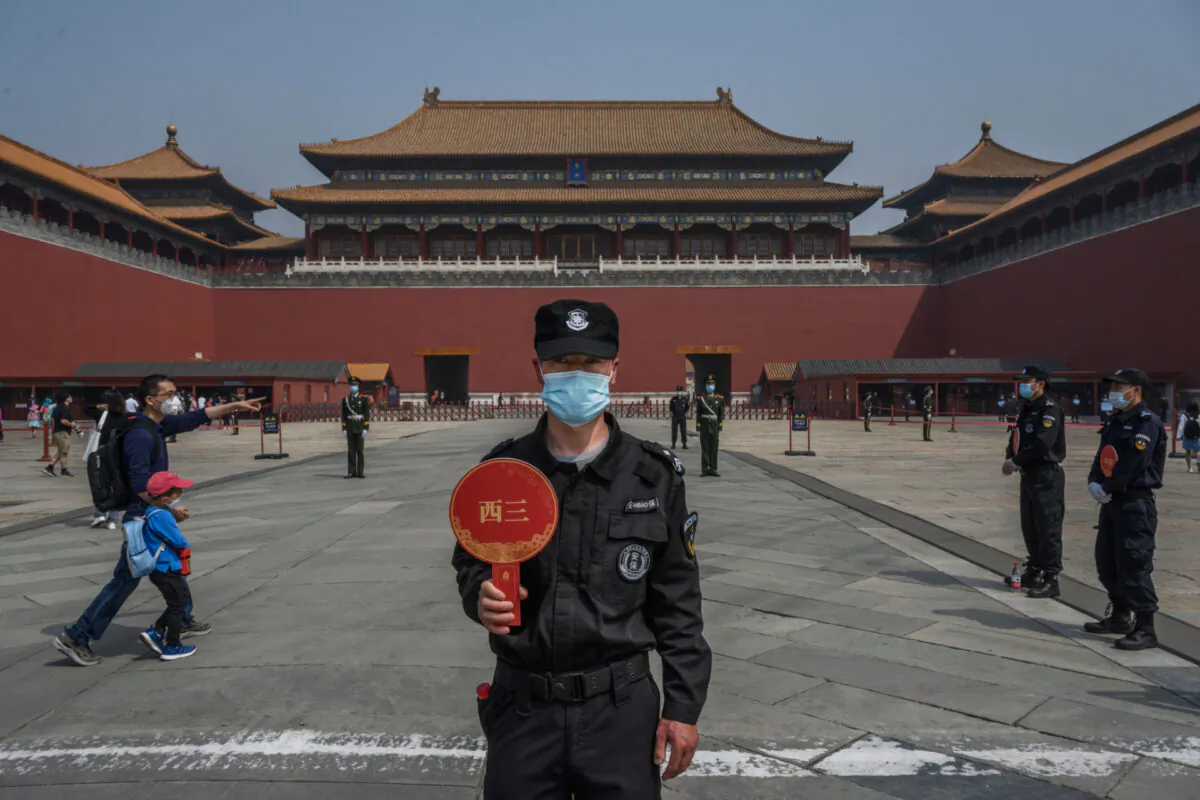A Chinese guard wears a protective mask as he stands at the entrance to the Forbidden City as it reopened to limited visitors for the May holiday, in Beijing on May 1, 2020. (Kevin Frayer/Getty Images)