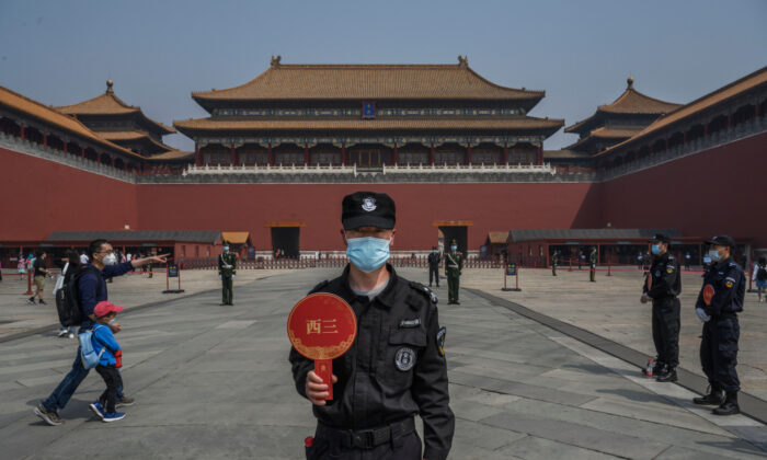 A Chinese guard wears a protective mask as he stands at the entrance to the Forbidden City as it reopened to limited visitors for the May holiday, in Beijing on May 1, 2020. (Kevin Frayer/Getty Images)

