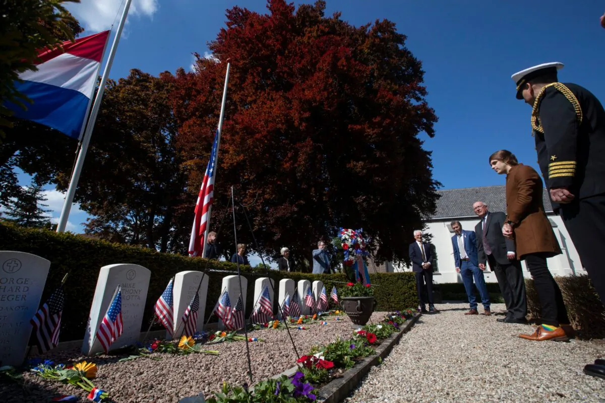Historian Sebastiaan Vonk, second right, and American Ambassador Peter Hoekstra, third from right, lay a wreath at the graves of eight members of the crew of an American B17 bomber shot down over the Netherlands on July 30, 1943, in the tiny rural village of Opijnen, Netherlands, on May 4, 2020. (Peter Dejong/AP Photo)