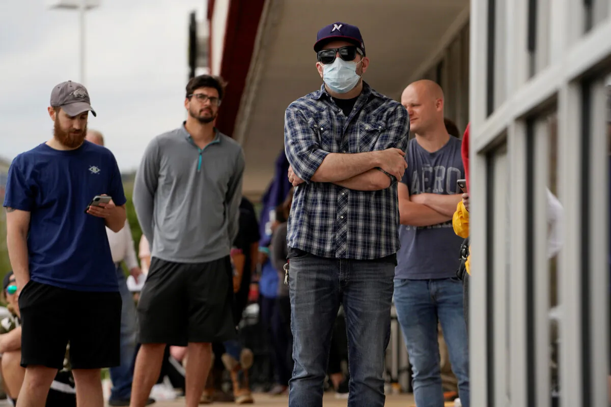 People who lost their jobs wait in line to file for unemployment at an Arkansas Workforce Center in Fayetteville, Ark., on April 6, 2020. (Nick Oxford/Reuters)
