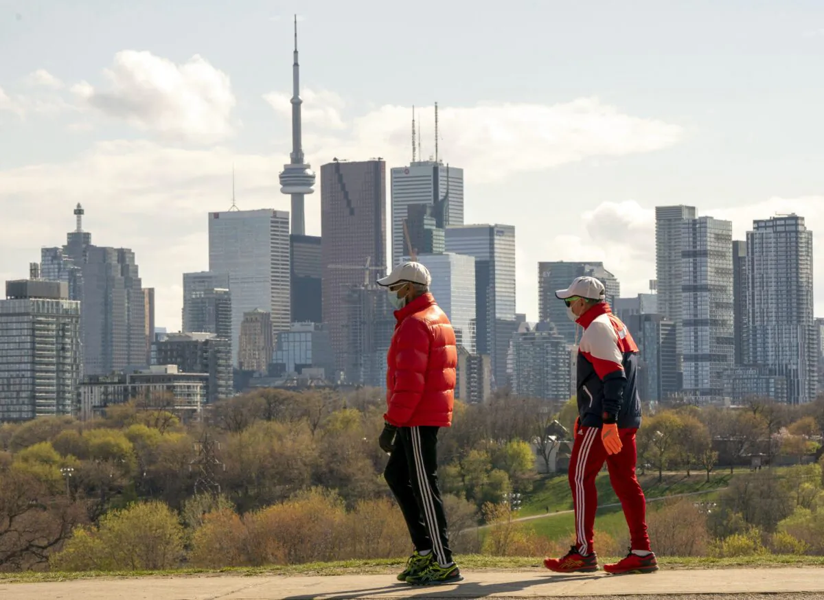 Men wearing masks to protect against COVID-19 take a walk in Toronto on May 7, 2020. (The Canadian Press/Frank Gunn)