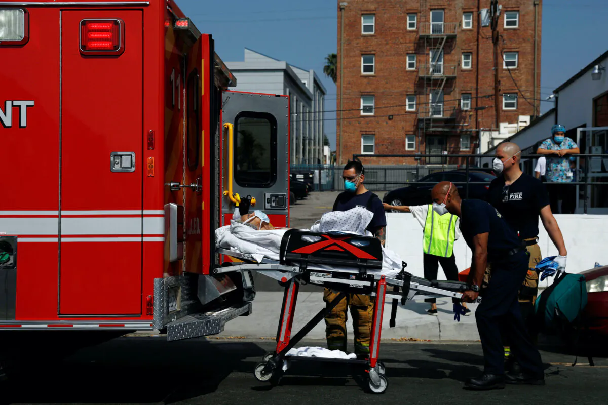 Los Angeles Fire Department (LAFD) emergency medical personnel, wearing face masks, transport a patient during the COVID-19 outbreak in Los Angeles, Calif., on May 9, 2020.  (Patrick T. Fallon/Reuters)