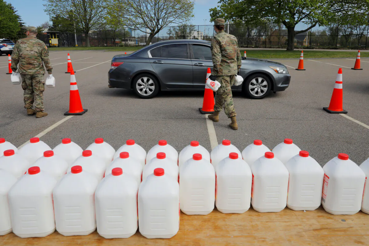 Members of the Massachusetts Army National Guard distribute free milk, offered instead of dairy farmers throwing away excess milk due to lower demand amid the COVID-19 outbreak, in Boston, Mass., on May 7, 2020. (Brian Snyder/Reuters)
