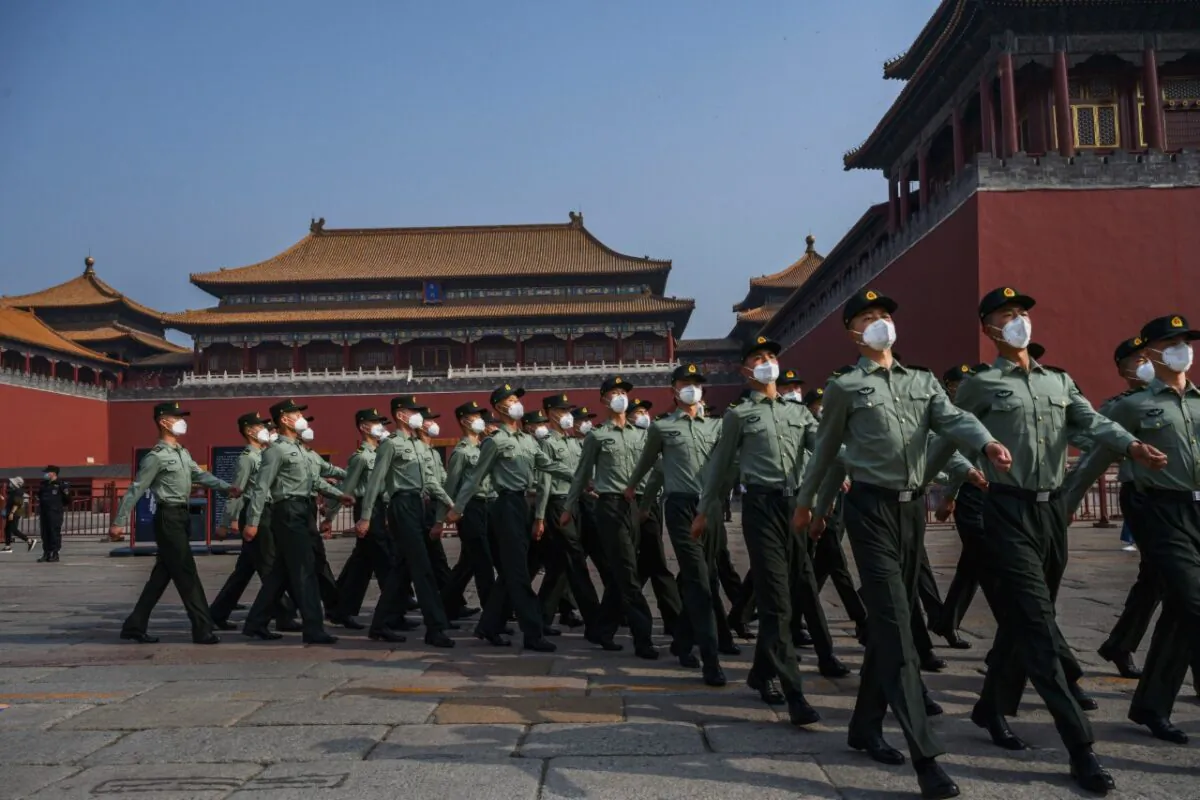 Chinese paramilitary police wear protective masks as they march by the entrance to the Forbidden City as it reopened to limited visitors for the May holiday, on May 2, 2020 in Beijing. (Kevin Frayer/Getty Images