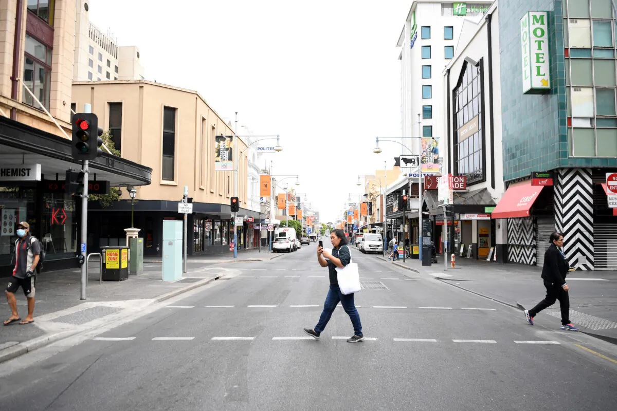 A woman crosses Hindley Street in Adelaide on April 1, 2020 in Adelaide. (Tracey Nearmy/Getty Images)
