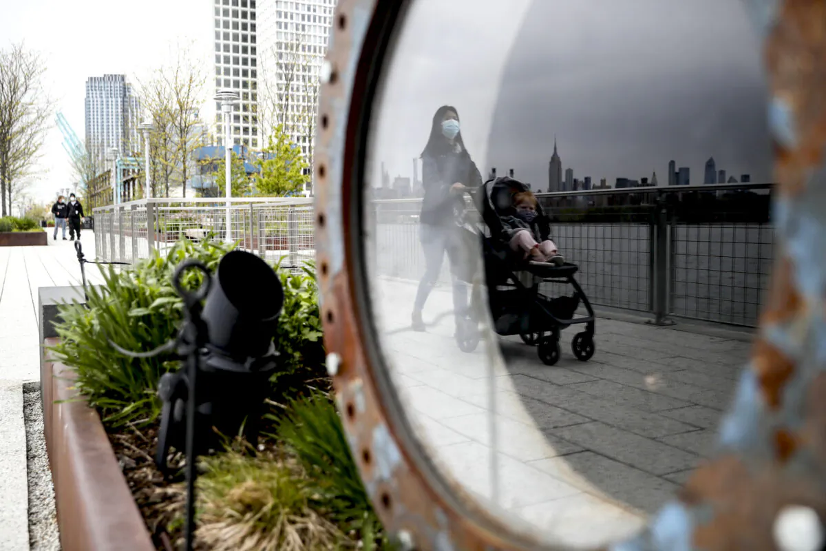 A visitor pushes a stroller while wearing a protective mask at Domino Park, in the Brooklyn borough of New York City, on May 8, 2020. (John Minchillo/AP Photo)
