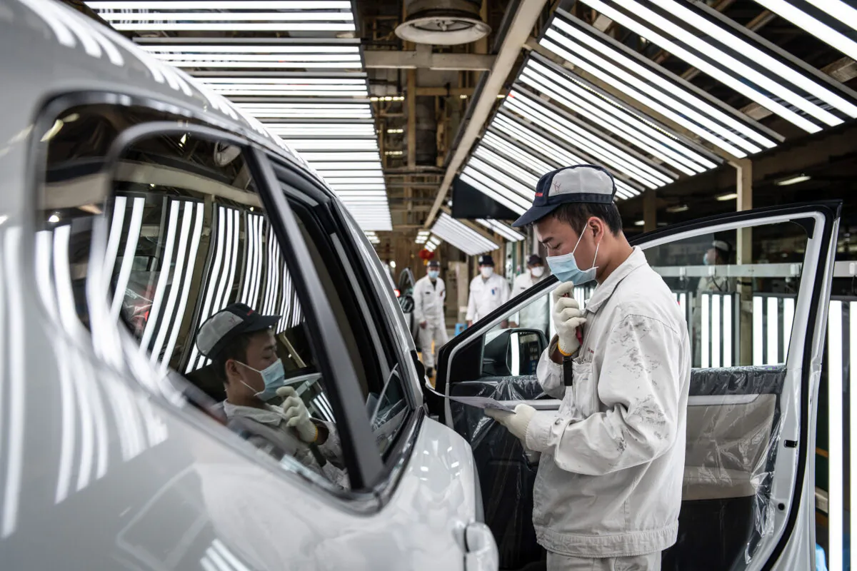 An employee wearing a face mask works on an assembly line at an auto plant of Dongfeng Honda in Wuhan city, Hubei Province, China, on April 7, 2020. (Photo by STR/AFP via Getty Images)