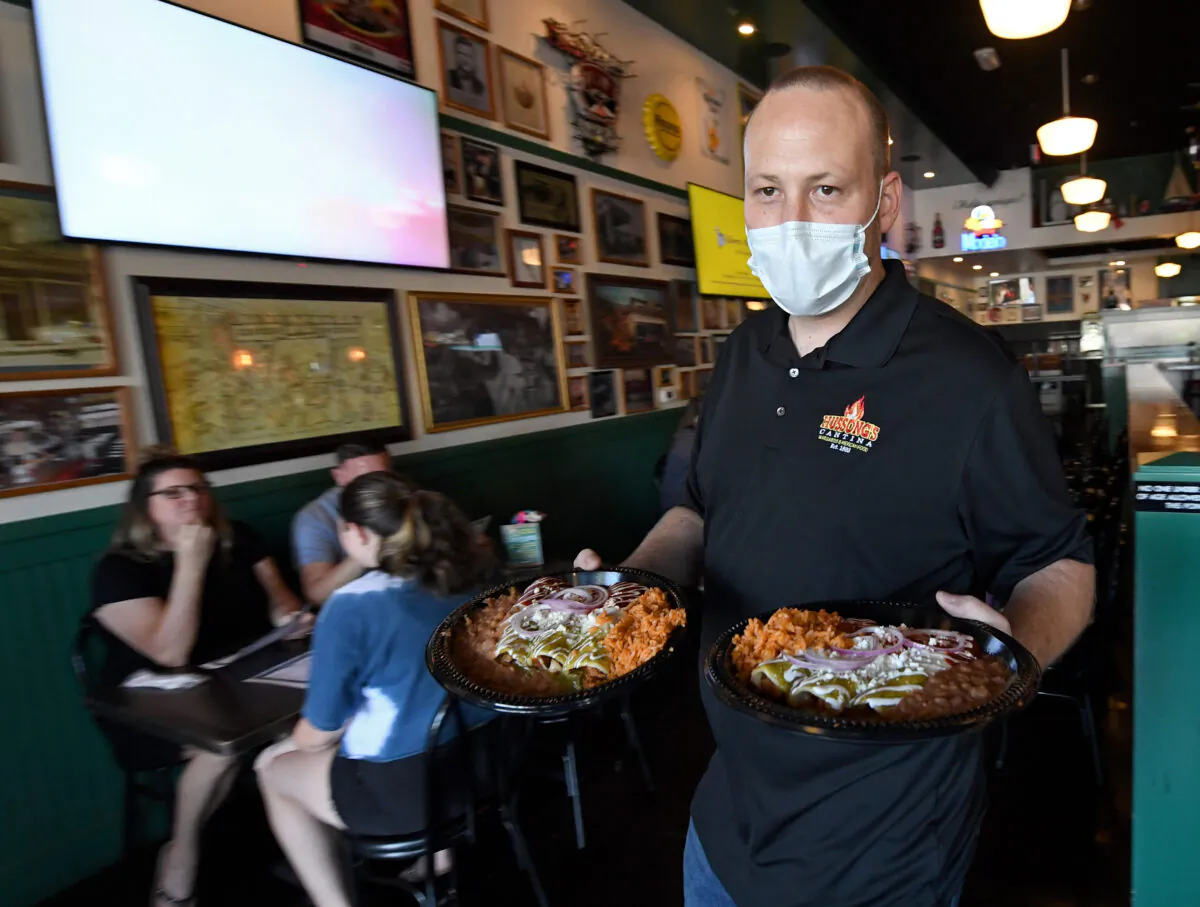 General manager Steven Hanson carries food to a table at Hussong's Cantina in Boca Park Fashion Village in Las Vegas on May 9, 2020. (Ethan Miller/Getty Images)