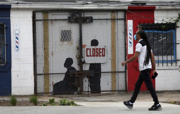 A pedestrian walks past a closed barber shop