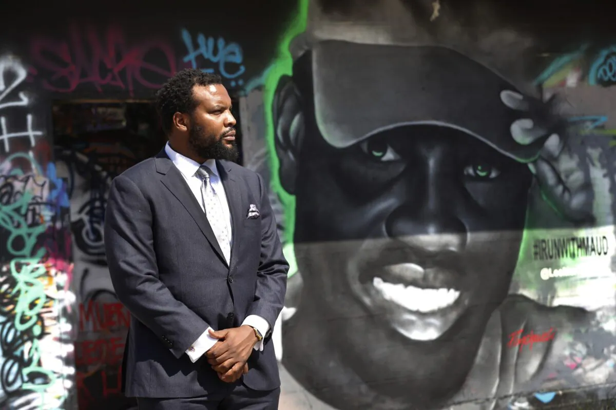 Lee Merritt, a lawyer representing the family of Ahmaud Arbery, poses for a photo by a mural in the likeness of Arbery painted by artist Theo Ponchaveli in Dallas on May 9, 2020. (Tony Gutierrez/AP Photo)