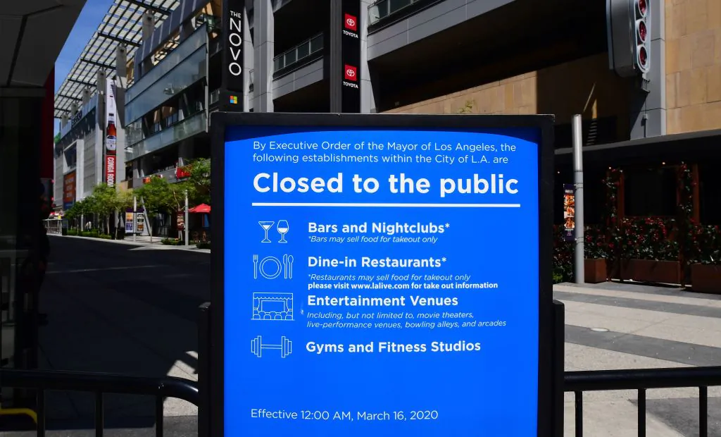 A sign in place since mid-March announces the temporary closures of restaurants, nightclubs, gyms, and entertainment venues at LA Live in Los Angeles on May 7, 2020. (Frederic J. Brown/AFP/Getty Images)
