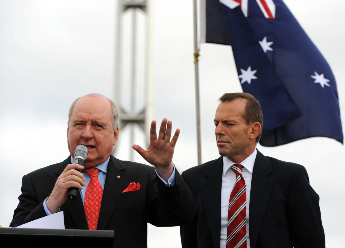 Conservative radio presenter Allan Jones (L) addresses the anti-carbon tax rally from The Convoy of No Confidence as Tony Abbott (R) looks on in front of Parliament House in Canberra on August 22, 2011.  (Torsten Blackwood/AFP via Getty Images)