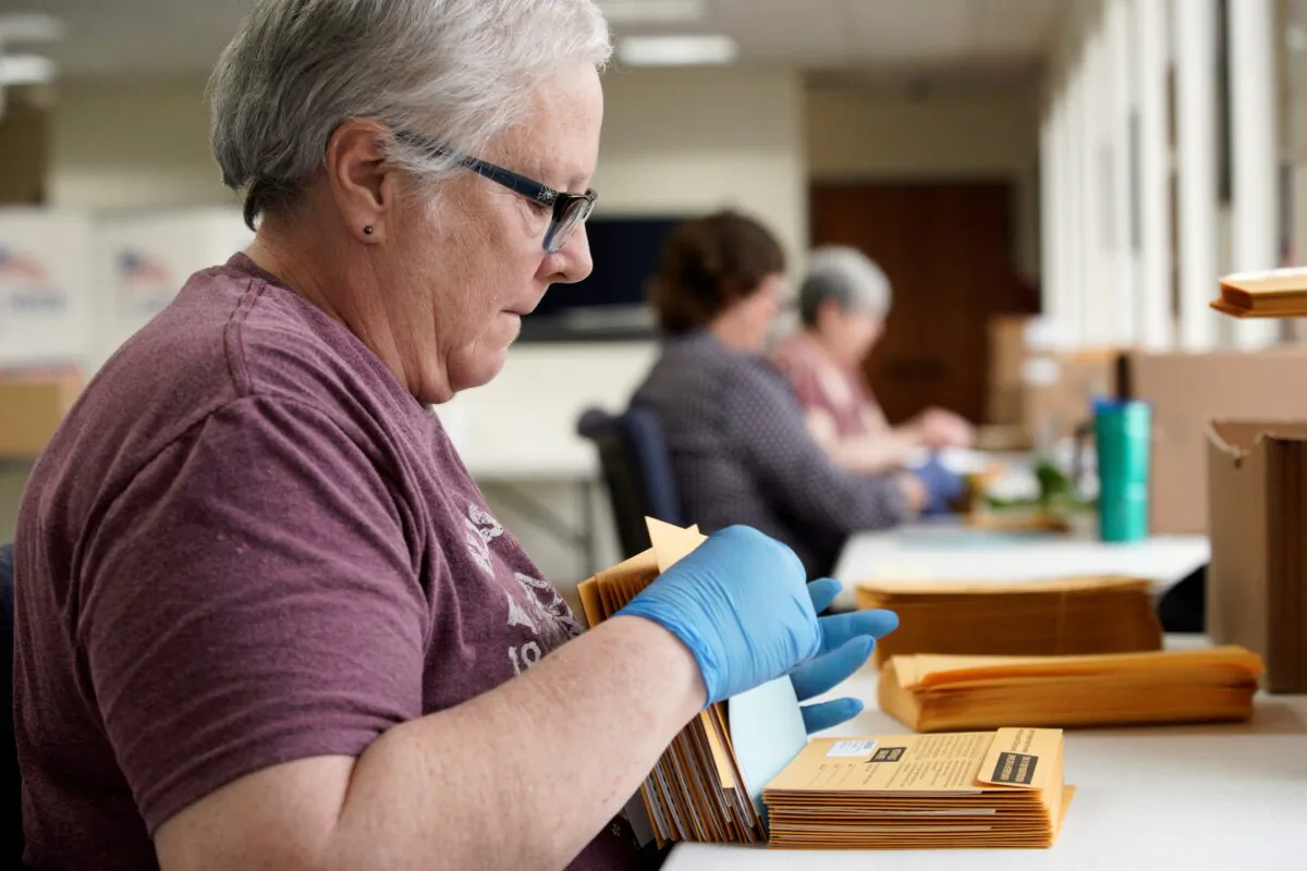 Pam Fleming and fellow workers stuff ballots and instructions into mail-in envelopes at the Lancaster County Election Committee offices in Lincoln, Neb., on April 14, 2020. (Nati Harnik/AP Photo)
