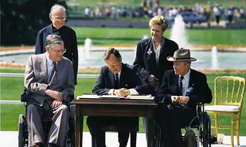 President George H.W. Bush signs the Americans with Disabilities Act into law on July 26, 1990. (Public Domain)