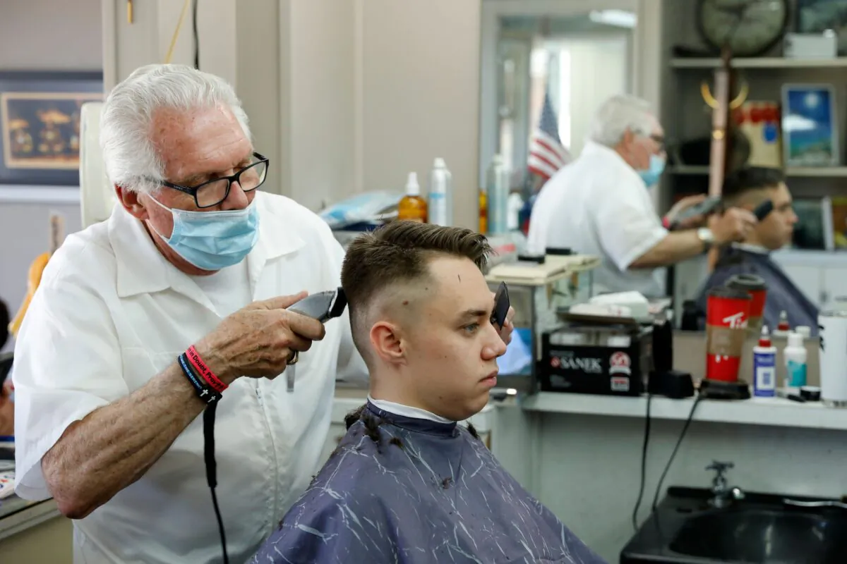 Barber Karl Manke cuts a client's hair at his barber shop in Owosso, Mich., on May 12, 2020. (Jeff Kowalsky/AFP/Getty Images)