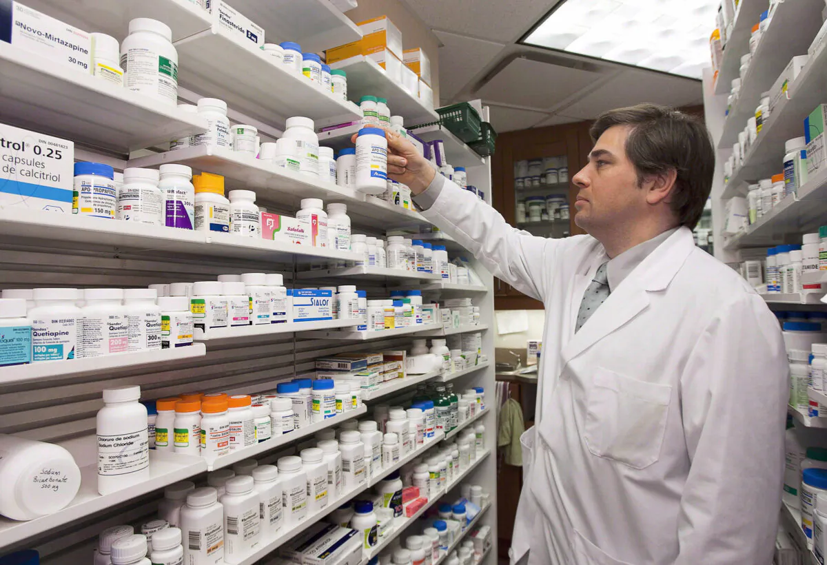 Pharmacist Denis Boissinot checks a bottle on a shelf at his pharmacy in Quebec City in this file photo. (The Canadian Press/Jacques Boissinot)