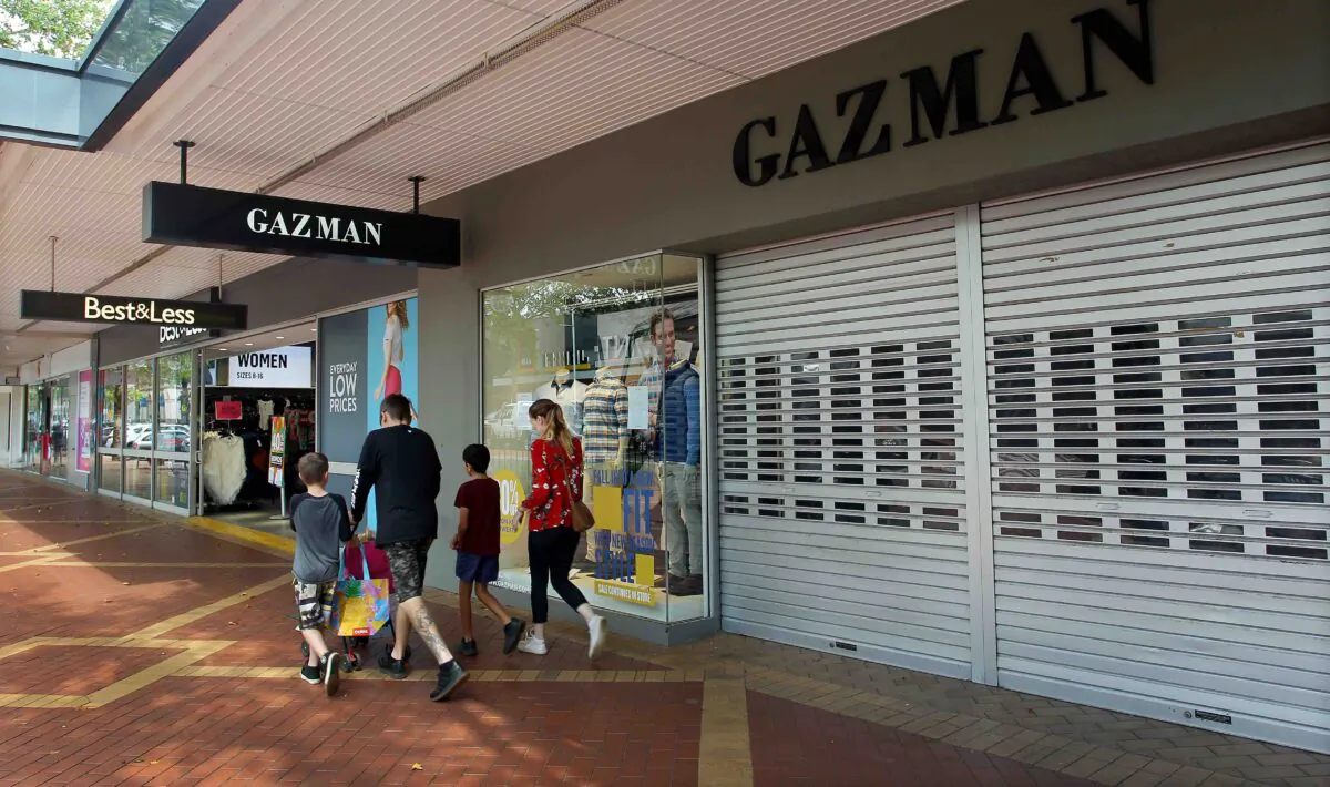 A family walks past closed retail stores along Peel Street in Tamworth, Australia, on April 4, 2020.(Lisa Maree Williams/Getty Images)