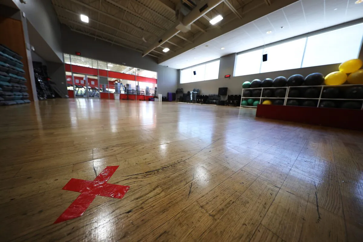 The letter X marked in red are placed on the floor of an exercise room more than seven feet apart at Gold's Gym Islip in N.Y. on May 13, 2020. (Al Bello/Getty Images)