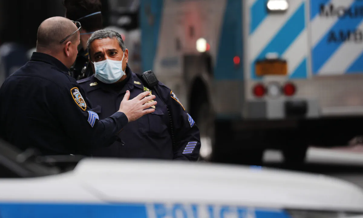 New York Police Department officers wear face masks as they attend to a crash involving a police officer in midtown along 5th Avenue in New York City on April 20, 2020. (Spencer Platt/Getty Images)