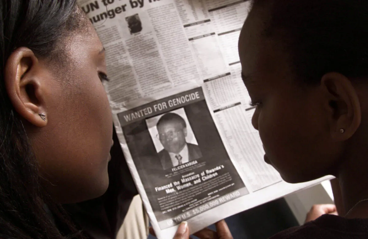 Readers look at a newspaper in Nairobi carrying the photograph of Rwandan Felicien Kabuga wanted by the United States on June 12, 2002. (George Mulala/Reuters)