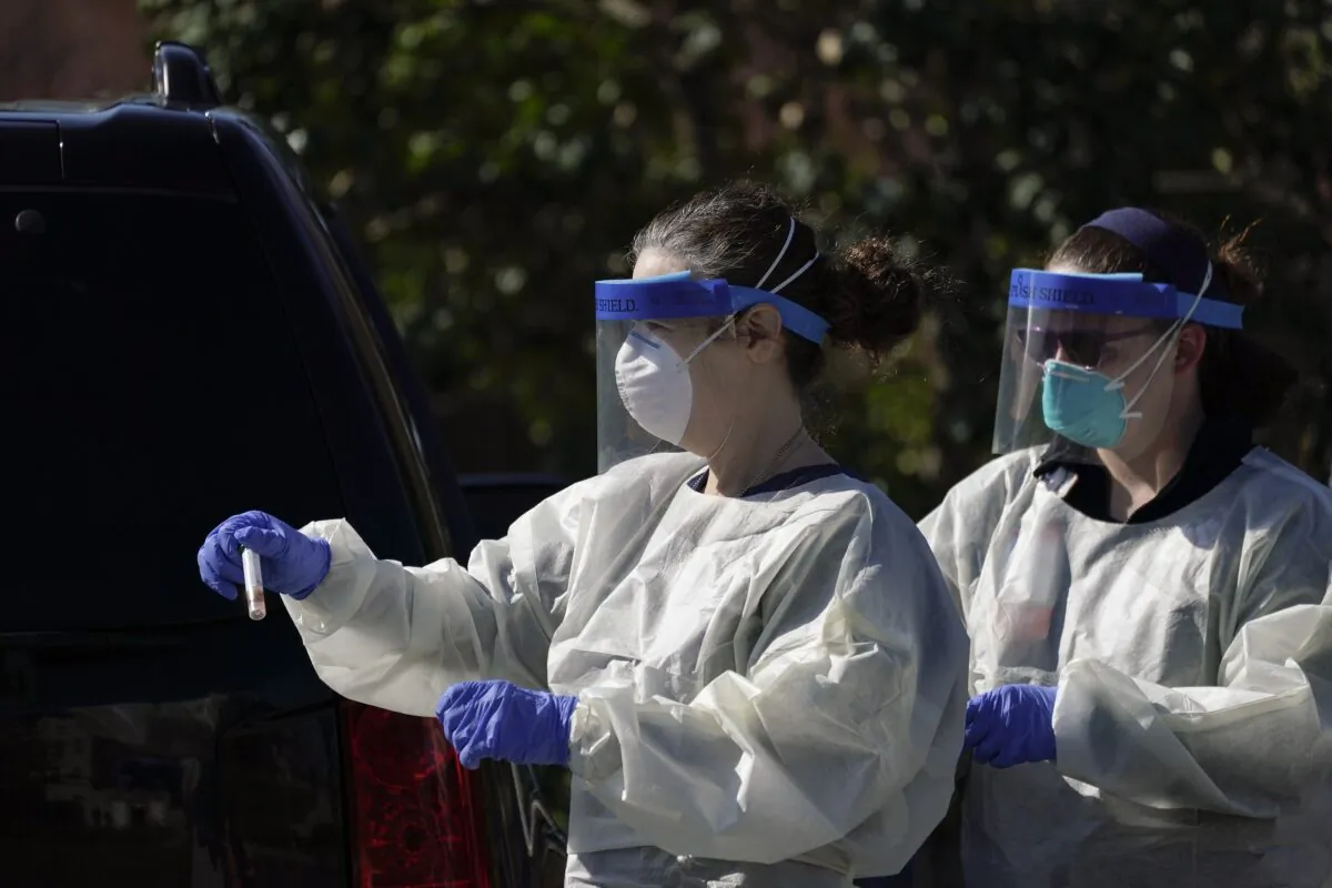A medical professional from Children's National Hospital carries a CCP virus specimen at Trinity University in Washington on April 2, 2020. (Drew Angerer/Getty Images)