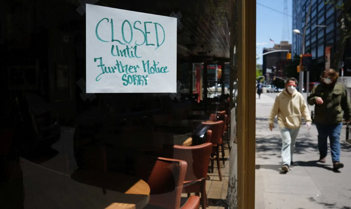 People walk through a shuttered business district in Brooklyn in New York City on May 12, 2020. (Spencer Platt/Getty Images)